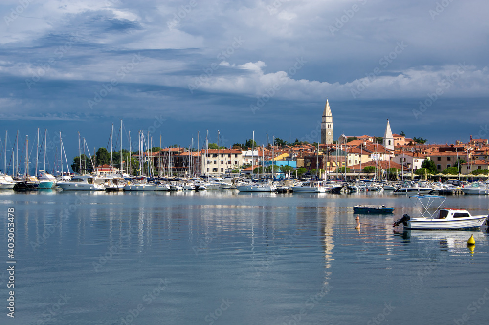 Touristic view of Izola Slovenia old fishing town historic center with church tower and marina