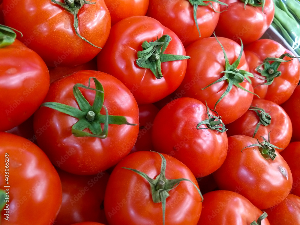 New harvest bright red tomatoes at the supermarket, food economy and vegetable prices in the market, staple food tomatoes New harvest bright red tomatoes at the supermarket, food economy and vegetable prices in the market, staple food tomatoes