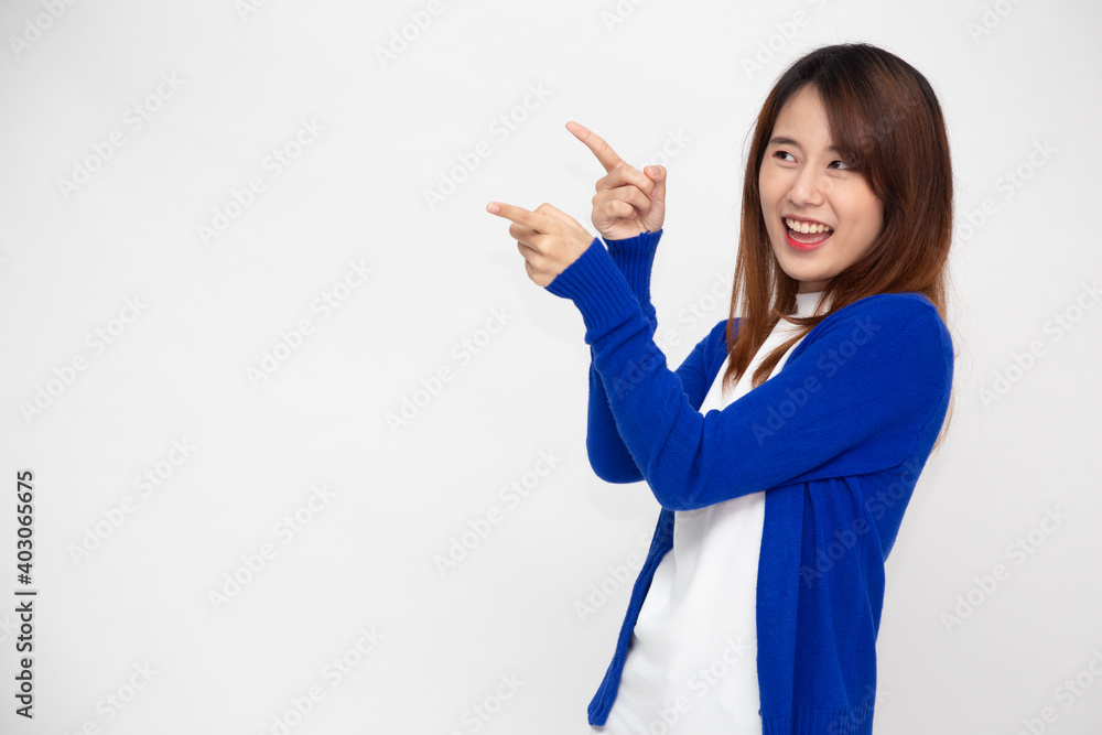 Young Asian woman smiling and pointing to empty copy space isolated on white background Young Asian woman smiling and pointing to empty copy space isolated on white background