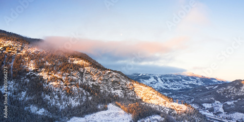 Drone photo from winter land Norway, Gol, Hallingdal. Shot in the cold in January in the blue hours early morning. Sun is rising and the frozen landscape is thawing.  photo