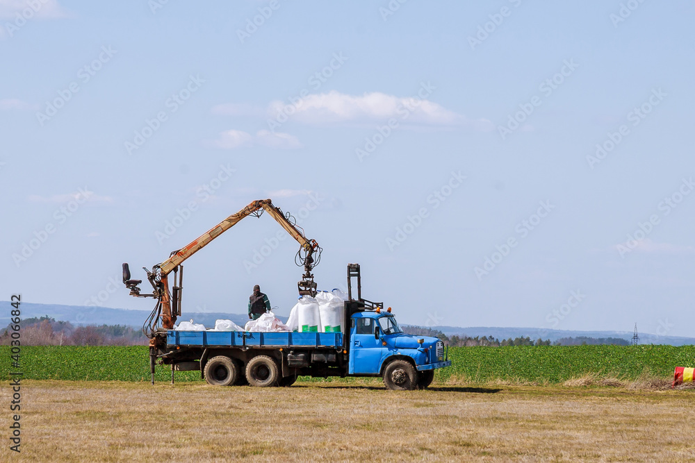 Fototapeta premium Tractor spreading fertilizer on grass field. Agricultural work.