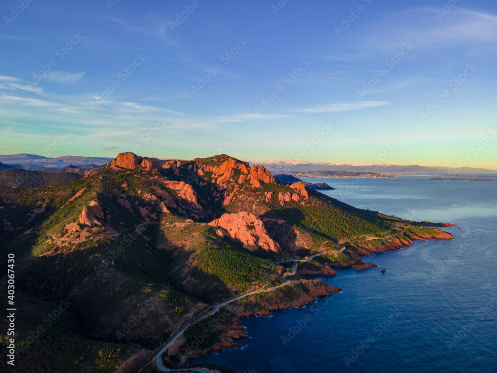 Massif de l'Esterel Aerial view during sunset, showing Cannes in the background with blue sky showing pine tree forest in the French Riviera, close to Cannes in Côte d'Azur, South of France