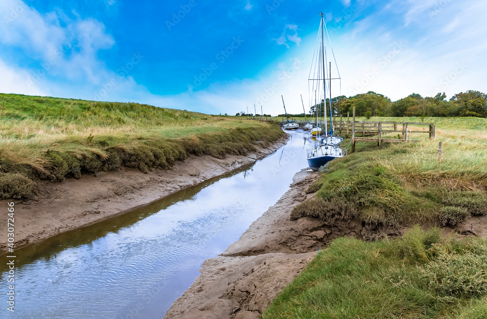 A muddy creek at low tide at Gibraltar Point near Skegness, UK on an Autumn afternoon