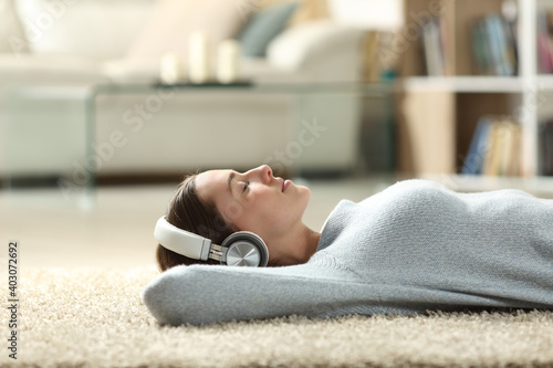 Relaxed woman listening to music with headphones at home