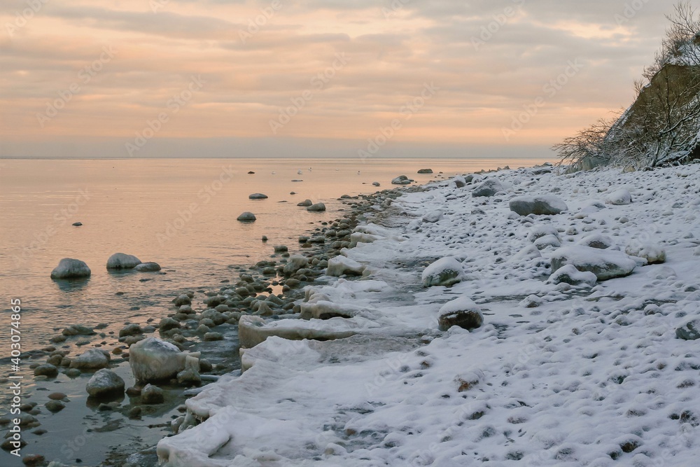 Snow covered shoreline with cliff coast by the Baltic Sea in winter.