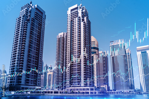 Skyscrapers of Dubai business downtown. International hub of trading and financial services of Western Asia. FOREX graph and chart concept. Double exposure. Dubai Canal waterfront.