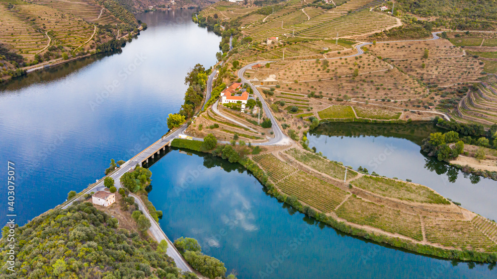 Drone eye of Rio surrounded by mountains planted with vineyards with bridge and lakes.