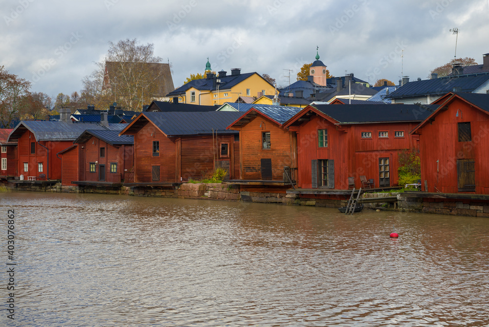 Old wooden houses on the banks of the Porvoonjoki river on a cloudy October day. Porvoo city symbol, Finland
