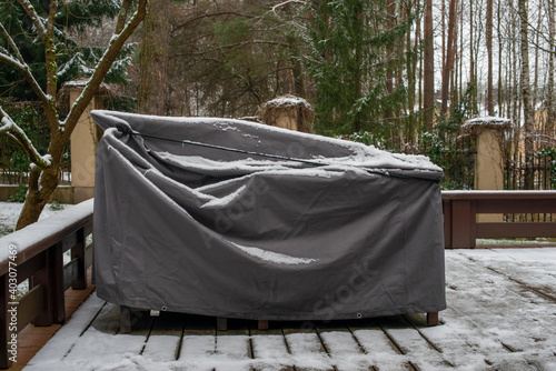 Patio furniture Cover protecting outdoor furniture from snow.