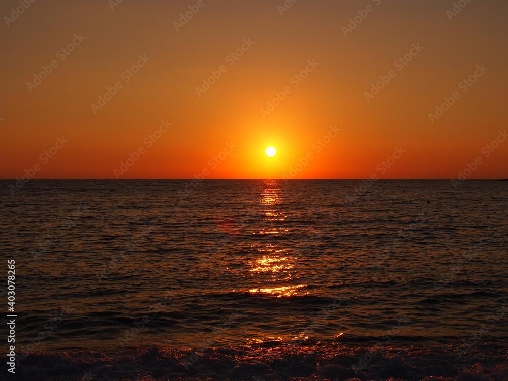 Sunset above the water on the beach in Alanya, Turkey.
