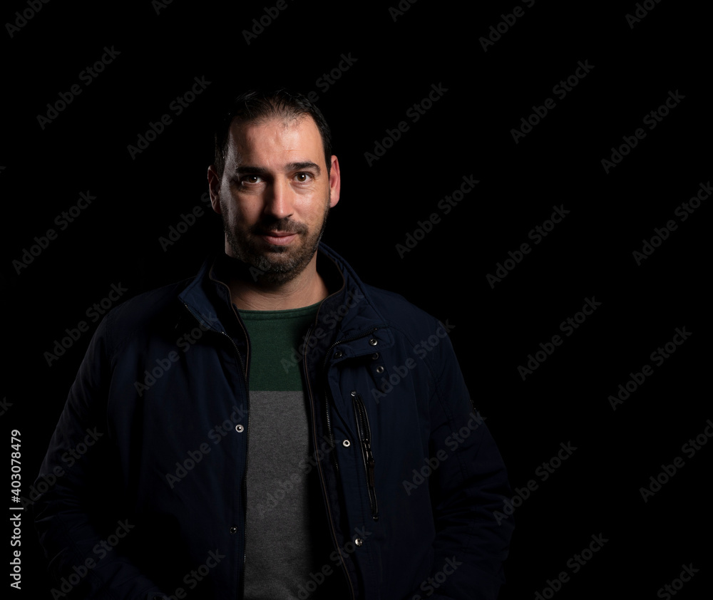 Attractive bearded man putting on a blue jacket posing isolated Attractive bearded man putting on a blue jacket posing isolated