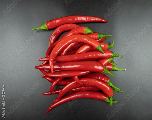 a bunch of red chili peppers on a black background, top view photo