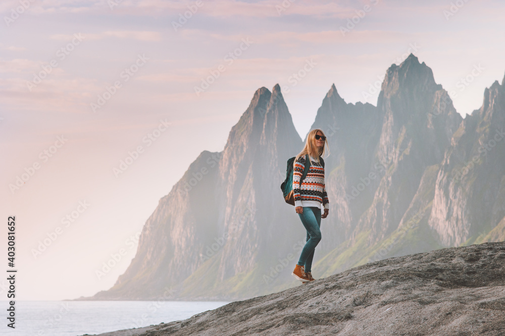 Obraz premium Tourist woman traveling in Norway active lifestyle vacations outdoor Okshornan peaks landscape Senja island