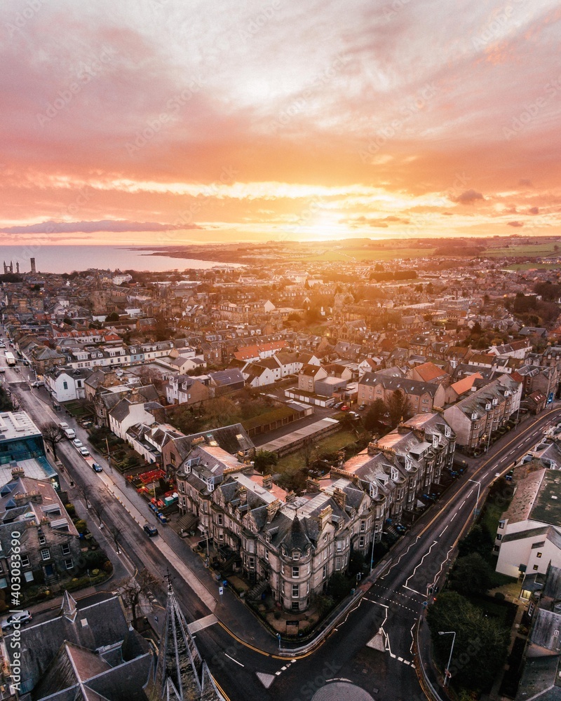 Fototapeta premium Aerial drone shot of St Andrews, Scotland while sunrise