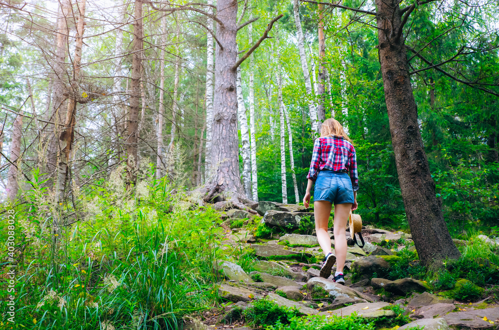 Hipster girl in the mountains. Stylish woman in straw hat and checkered shirt in forest. Wanderlust concept. Travelling and hiking in summer. mysterious wood. Beautiful nature. Hipster girl in the mountains. Stylish woman in straw hat and checkered shirt in forest. Wanderlust concept. Travelling and hiking in summer. mysterious wood. Beautiful nature.