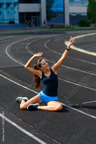 Outdoor shot of young woman athlete running on racetrack. Professional sportswoman during training.