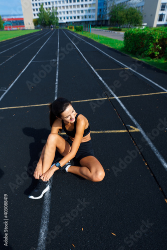 Outdoor shot of young woman athlete running on racetrack. Professional sportswoman during training.