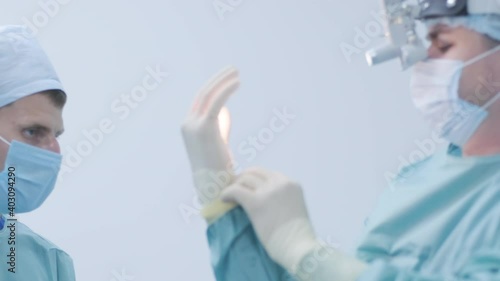 Nurse helping the surgeon to put on sterile gloves before surgery