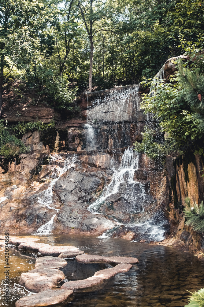 Fototapeta premium Beautiful small waterfall flows into the forest pond at the end of the hiking path of Faial da Terra, Sao Miguel, Azores.