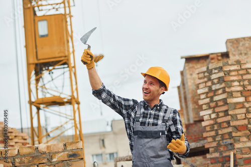 Construction worker in uniform and safety equipment have job on building