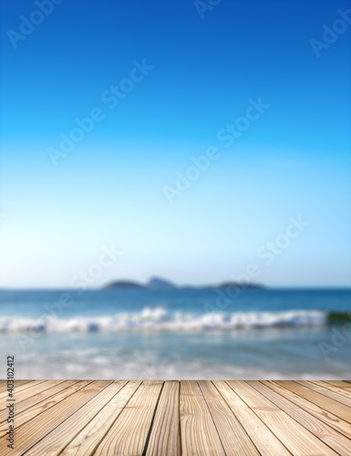 Empty stage for products. Blurred sea background with wood resort deck floor in foreground. Image of Ipanema beach in Rio de Janeiro, Brazil.