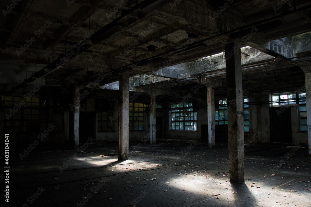 Abandoned industrial hall - dirty, neglected room with broken windows