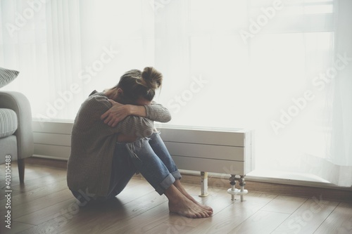 Quadro su tela A lonely young woman feels depressed and stressed as she sits on the floor with her head in her hands
