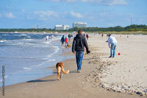 Fototapeta Naklejka Na Ścianę i Meble -  Urlauber beim Spaziergang am Strand von Swinemünde an der polnischen Ostseeküste 