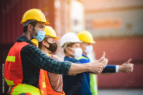 Workers person wear protective surgical face masks for safety in machine industrial factory, container yard manufacturing site, foreman and engineer