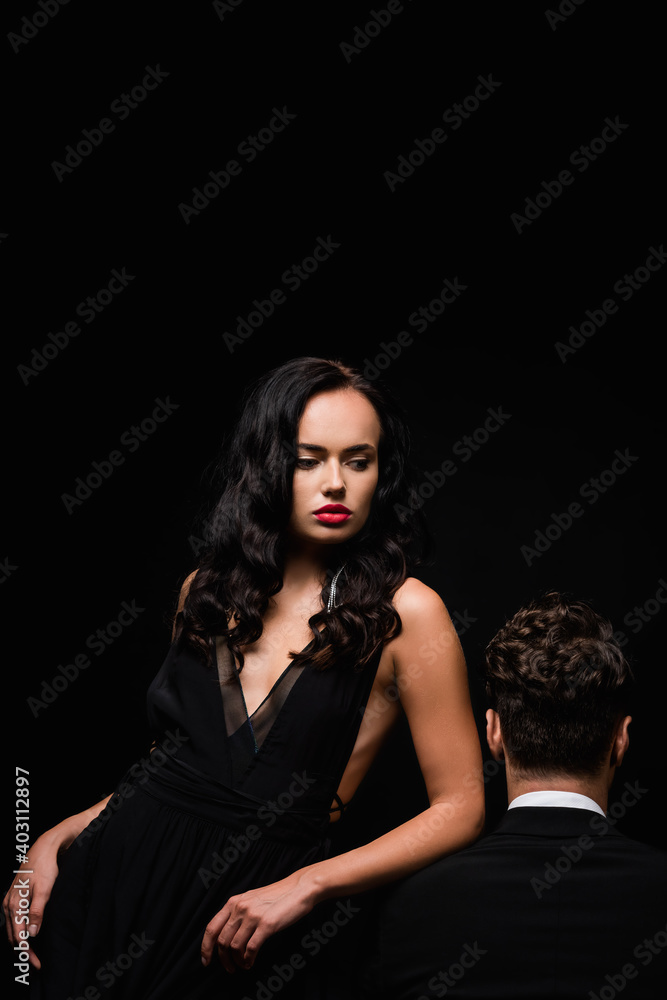seductive woman with red lips near man in suit isolated on black