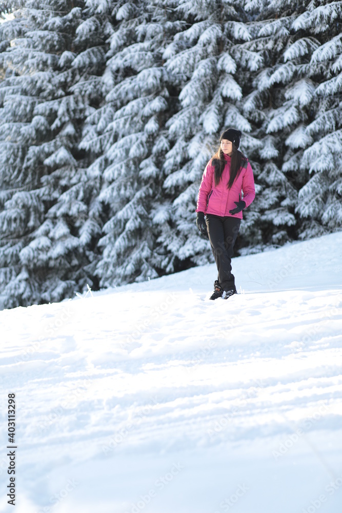 Girl on winter snowy fir tree background on ski resort