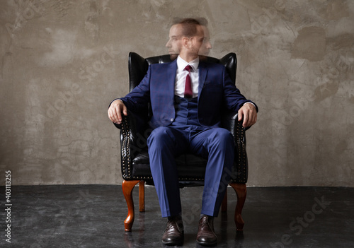 Fényképezés Businessman with split personality sitting in armchair