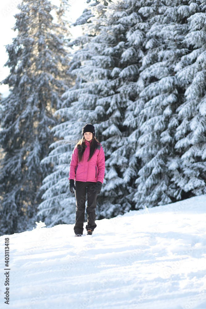 Girl on winter snowy fir tree background on ski resort