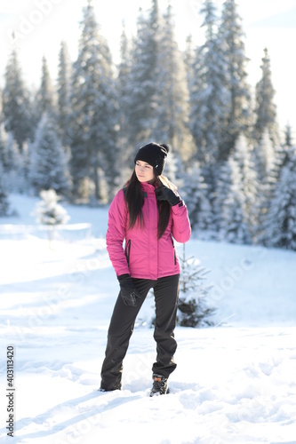 Girl on winter snowy fir tree background on ski resort