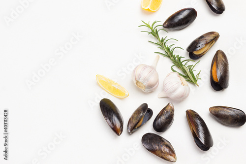 Mussels with lemon, garlic  and rosemary are scattered on table