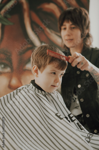 The work of the barbershop. Haircut of a boy in a barbershop. Children's haircut