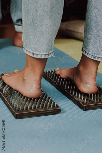 Group practice of standing on nails. Closeup of yoga person standing on sadhu board with sharp nails. Sadhu wooden board with nails for sadhu practice.