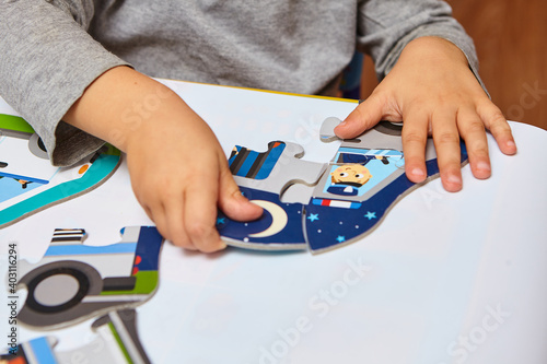 Child playing with puzzles,. The boy is playing in his room. Educational logic toys for kid's..