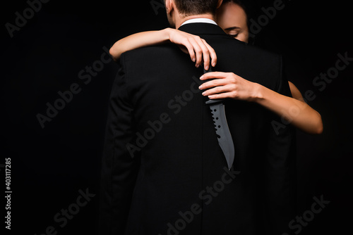 Картината върху платно cropped view of dangerous woman holding knife behind back of man isolated on bla