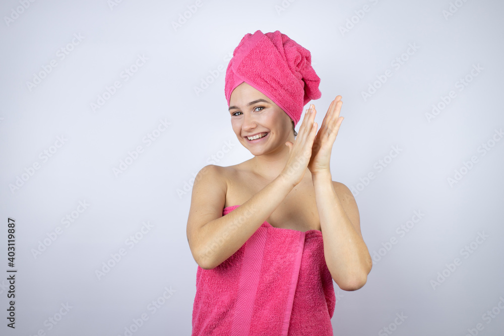 Young beautiful woman wearing shower towel after bath standing over isolated white background clapping and applauding happy and joyful, smiling proud hands together Young beautiful woman wearing shower towel after bath standing over isolated white background clapping and applauding happy and joyful, smiling proud hands together