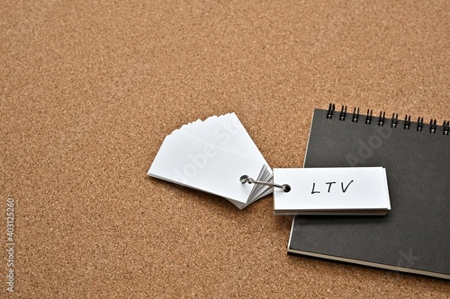 On top of the notebook on the cork board is a wordbook with the word LTV written on it. It means Life Time Value. photo