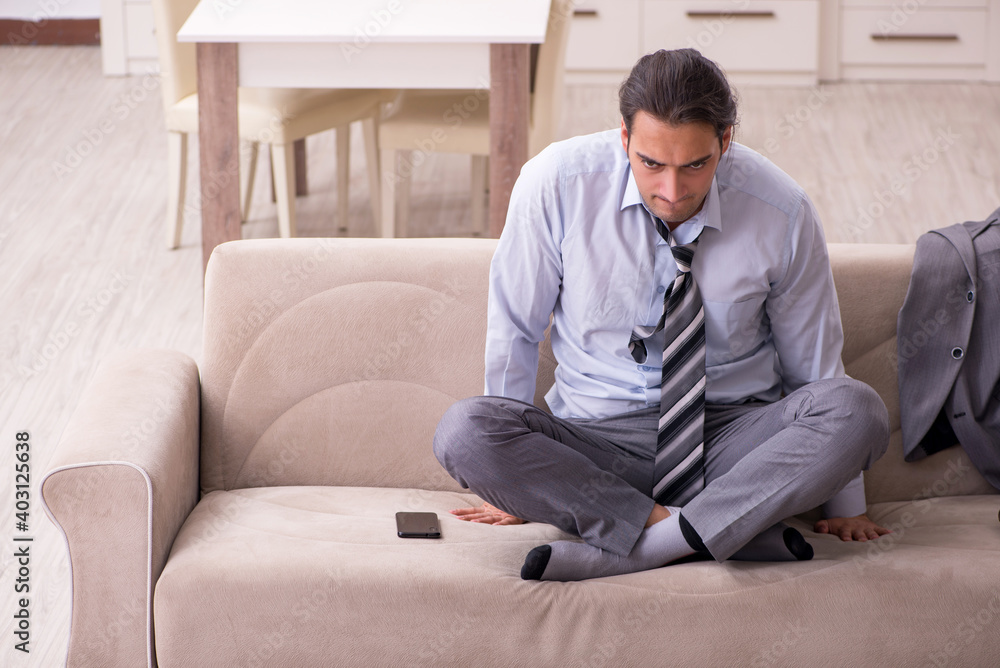 Tired young businessman coming home after working day Tired young businessman coming home after working day