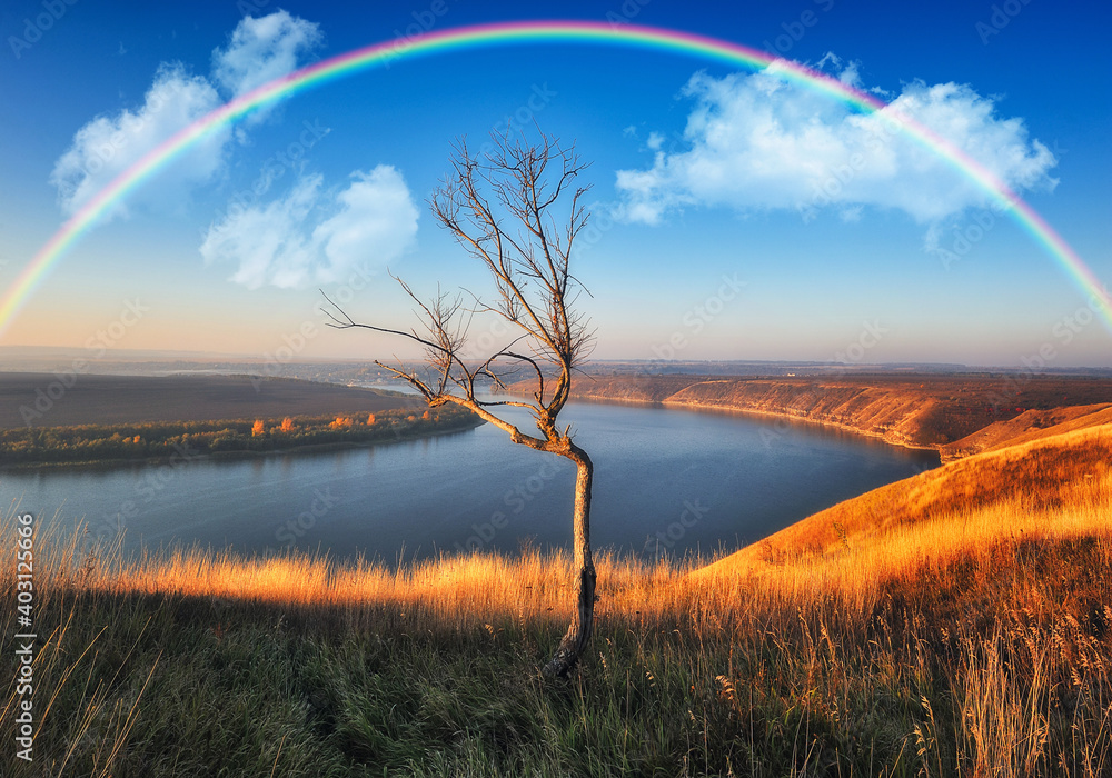 Obraz premium colorful rainbow over river canyon. autumn landscape