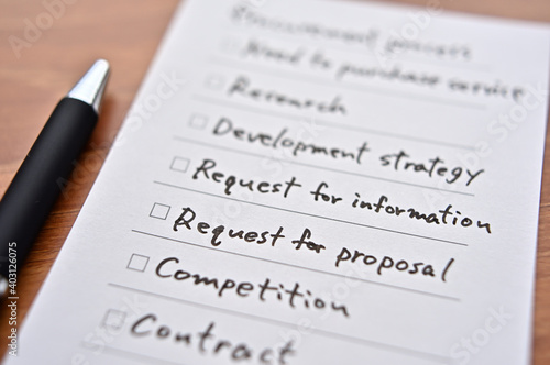 There's a piece of paper on the desk with a "procurement process" checklist. It is focus in Request for proposal.