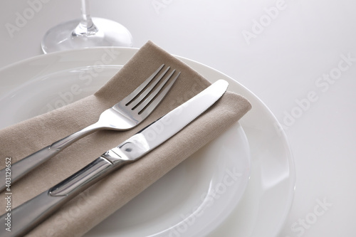 Elegant cutlery with napkin on white table  closeup