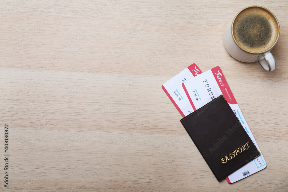Avia tickets, passport and cup of coffee on wooden table, flat lay with space for text. Travel agency concept Avia tickets, passport and cup of coffee on wooden table, flat lay with space for text. Travel agency concept