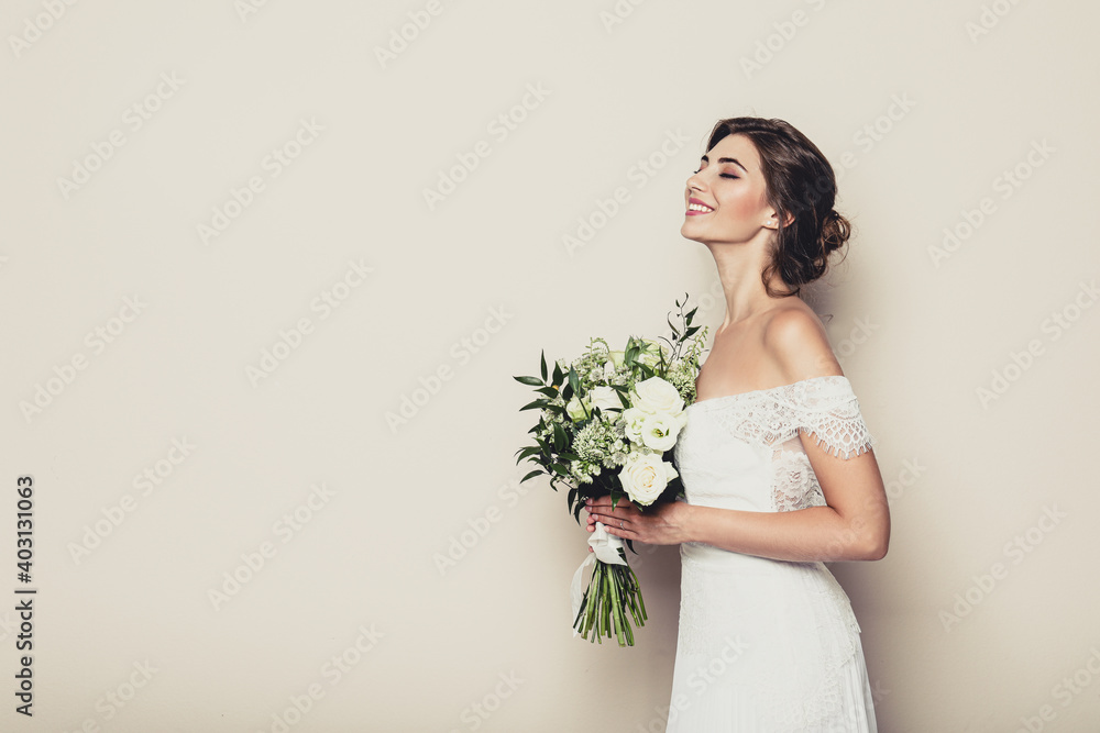 Young bride wearing wedding dress with beautiful bouquet on beige background. Space for text Young bride wearing wedding dress with beautiful bouquet on beige background. Space for text