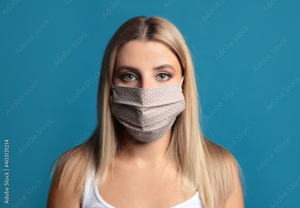 Young woman in protective face mask on blue background Young woman in protective face mask on blue background