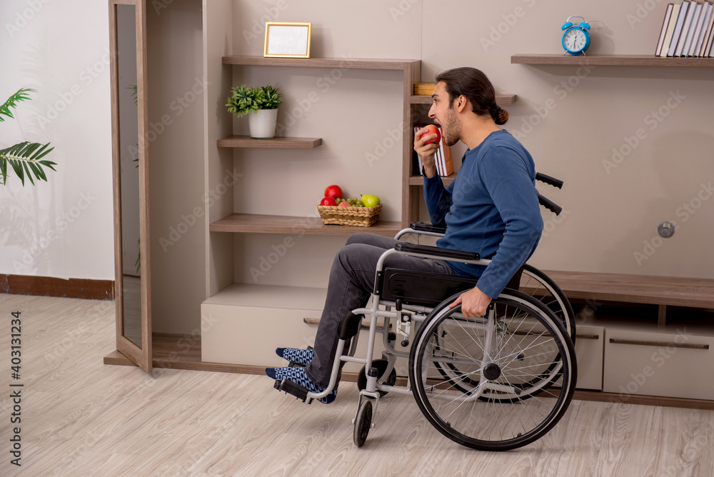 Young man in wheel-chair suffering at home Young man in wheel-chair suffering at home
