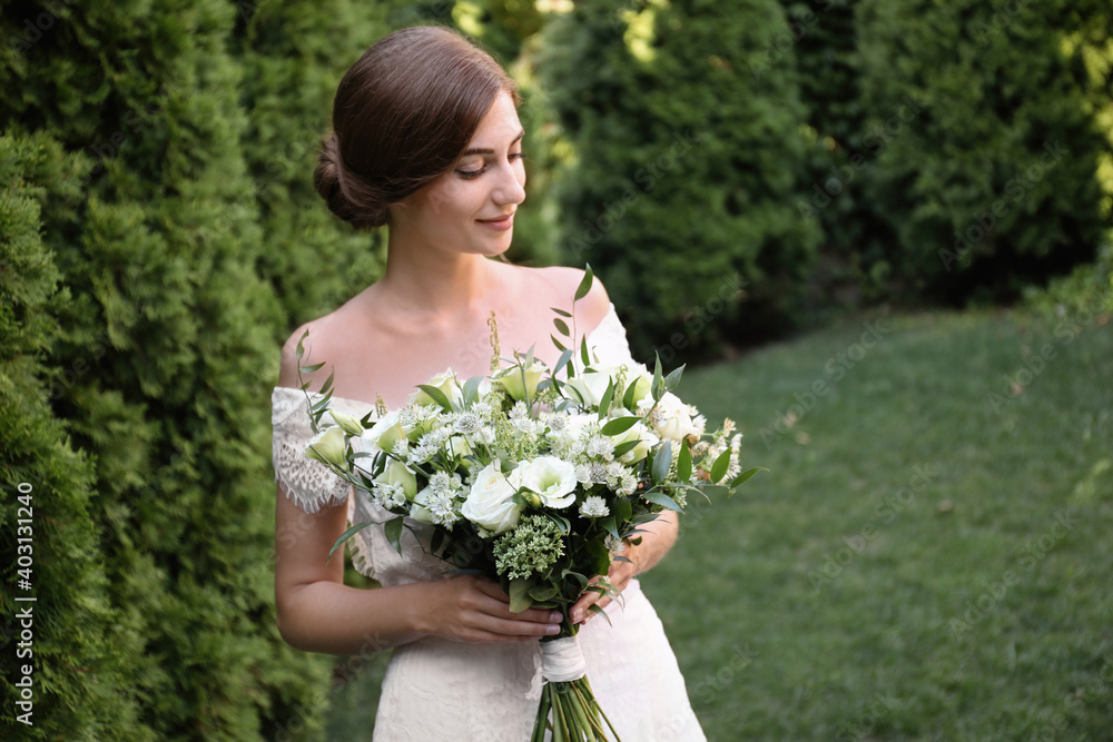 Gorgeous bride in beautiful wedding dress with bouquet outdoors Gorgeous bride in beautiful wedding dress with bouquet outdoors